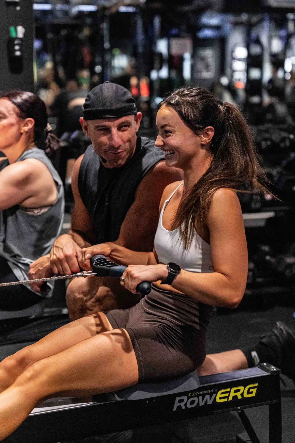 A Sparc Up coach supporting a member on the rower